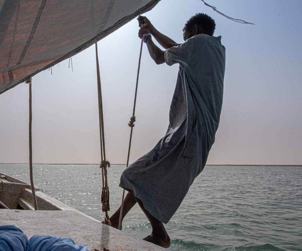 A fisherman pulls on the sails of an artisan fishing boat in Mauritania
