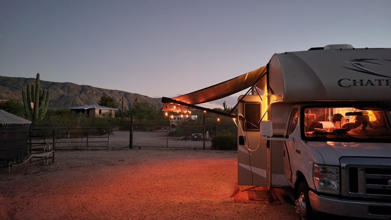 Twilight shot of Lareine with the awning out and lights hanging from the edge.