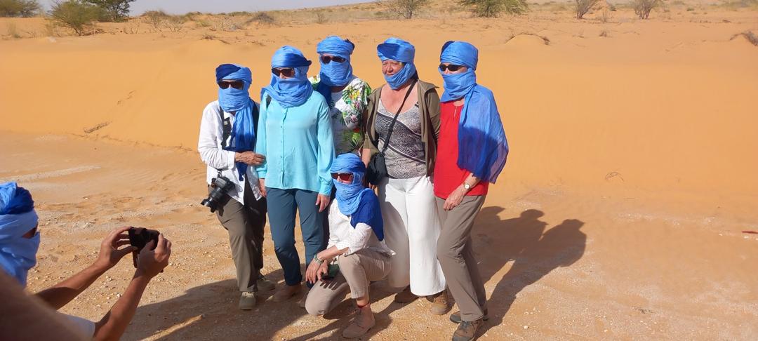 A small group poses for a photo in the desert
